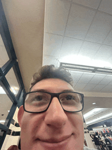 a man wearing glasses is smiling and looking up