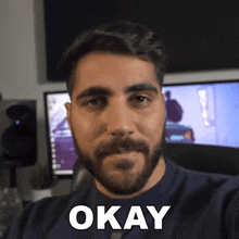 a man with a beard is smiling and says okay