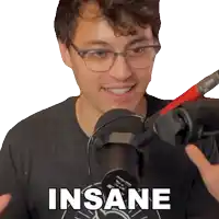 a man wearing glasses stands in front of a microphone with the word insane on his shirt