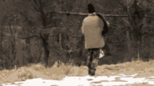 a man is walking in the snow carrying a pole