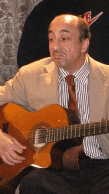 a man in a suit and tie playing a guitar