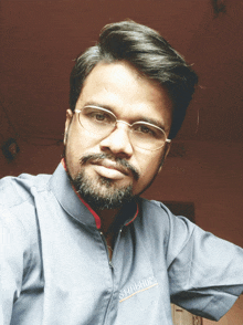 a man wearing glasses and a shirt that says shahum on it