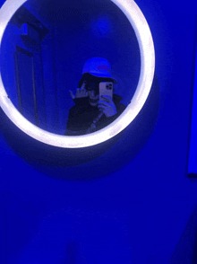 a person taking a picture of themselves in a mirror with blue lights