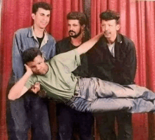 a group of men are posing for a picture with one of them laying on the floor .