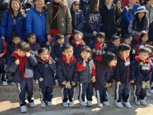 a group of children are posing for a picture and one of them is wearing a name tag that says ' a ' on it