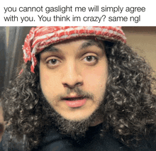 a man with curly hair and a beard is wearing a red white and black hat