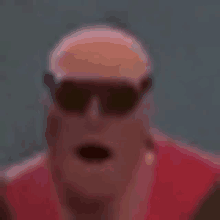 a man wearing sunglasses and a red jacket is making a funny face .