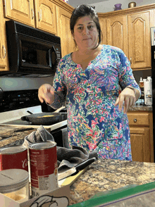 a woman cooking in a kitchen with a can of tomato soup