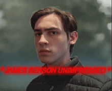 a close up of a young man with the words james benson unimpressed behind him