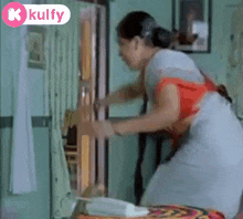 a woman is opening a door in a room with a kulfy logo on the bottom .