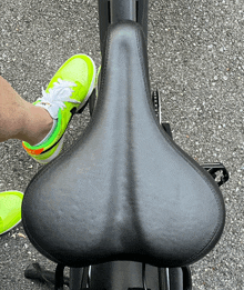 a person wearing neon green nike shoes sits on a bike