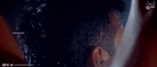 a close up of a man taking a shower with a towel on his face .