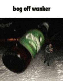 a man is standing next to a bottle of carlsberg beer in the snow .