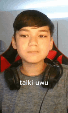 a young boy wearing headphones with the words taiki uwu on the bottom