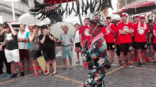 a man in a kimono stands in front of a crowd wearing a red shirt that says ' nba '