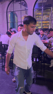 a man in a white shirt is dancing in front of a crowd