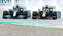 two racing cars are racing on a race track .