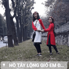 two girls standing next to each other with the words ho tay long gio em d.. below them