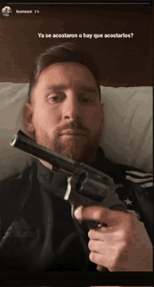 a man laying in bed holding a gun with the words ya se acostaron o hay que acostarlos below him