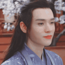 a man with long hair wearing a blue kimono