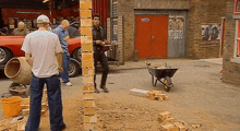 a group of men are standing in front of a building with a sign that says ' ambulance ' on it