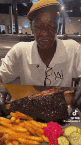a man is sitting at a table eating a large piece of meat