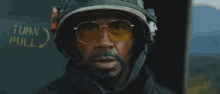 a soldier wearing sunglasses and a helmet says " survive "