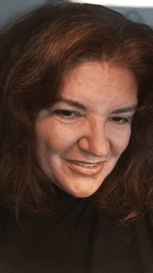 a close up of a woman 's face with a smile