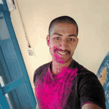 a man is covered in pink powder and smiling