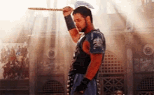 a gladiator is holding a large axe in his right hand