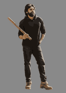 a man with a beard is holding a wooden stick in his right hand