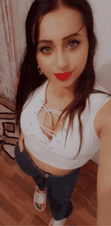 a woman taking a selfie with a white top and jeans