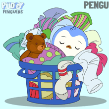 a penguin is sleeping in a laundry basket with clothes and a teddy bear