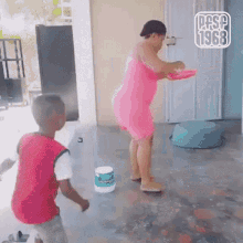 a woman in a pink dress is standing next to a boy in a pink shirt and a sign that says pasp 1968