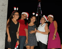 a group of women wearing santa hats and headbands pose for a picture