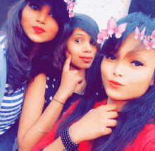 three girls posing for a picture with one wearing a flower crown