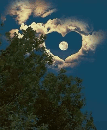 a heart shaped moon is surrounded by clouds in the night sky .