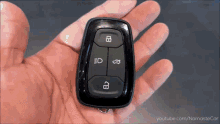 a close up of a hand holding a car key with youtube.com in the corner