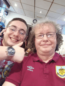 a man wearing a maroon shirt with umbro on it