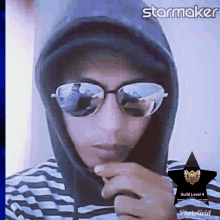 a man wearing sunglasses and a hoodie has a starmaker logo on his photo