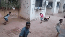 a man in a red shirt with the number 10 on it is playing soccer with a group of children .