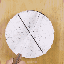 a person is cutting a cake with a knife on a cutting board that says easy plus on the bottom