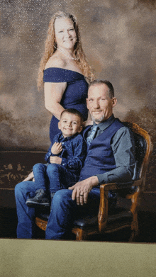 a family posing for a picture with a man sitting in a chair and a woman standing behind them