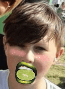 a boy with a lime in his mouth and green lips