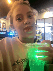 a little girl holding a cup that says halloween