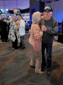 a man wearing a hat that says nyc on it is dancing with a woman