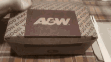 a box of agw sits on a table with a fork and knife