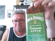 a man is holding up a bottle of jack daniels tennessee apple