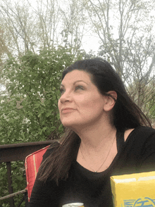 a woman sits on a deck with a can of soda and a box of ea