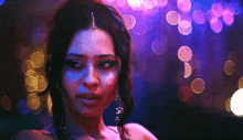 a close up of a woman 's face in front of a blurry background of lights .